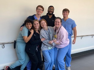 group of residents in scrubs standing in a hallway
